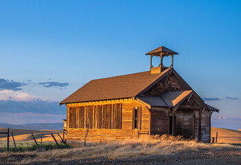 Old Abandoned One Room Schoolhouse glowing in the late afternoon light.  Wasco County, Oregon