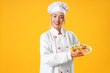 Female chef with tasty pasta on yellow background