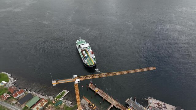 Ferry Haroy from Fjord-1 company departing Eidsdal ferry pier and heading to Linge in western Norway - High angle aerial showing departure of ferry and construction work on quay
