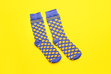 Pair of stylish socks on yellow background