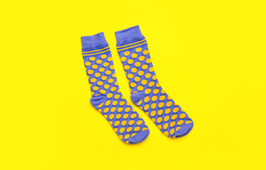 Pair of stylish socks on yellow background
