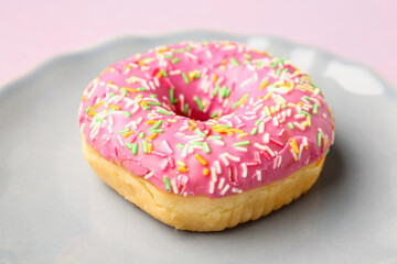 Plate with sweet donut on light background, closeup