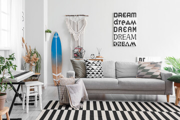 Interior of stylish living room with surfboard, synthesizer and sofa