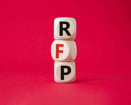 RFP - Request for Proposal. Wooden cubes with word RFP. Beautiful red background. Business and Request for Proposal concept. Copy space.