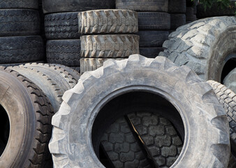 Obraz premium End-of-life vehicle tires in various sizes. Scrap tires for recycling.