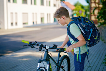 Handsome preteen boy going to school on bike. Teenager ride bicycle. Safe way to high school. Happy...