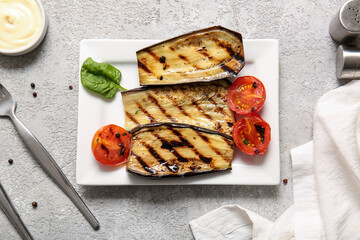 Plate with delicious grilled eggplants and tomatoes on grey background