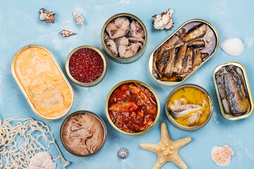Variety of opened tins with different types of canned fish and seafood. Natural source of omega 3 and vitamin d