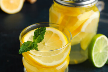 Glass of infused water with lemon on black background