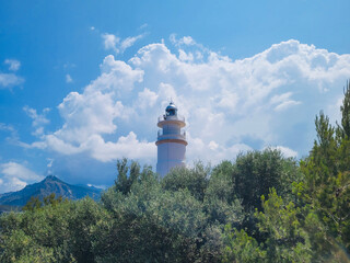 View of the Cap Gros lighthouse, among the green vegetation of the mountain, Balearic Islands.