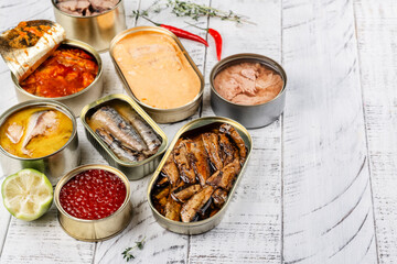 Variety of opened cans with different types of fish and seafood