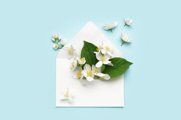 Composition with envelope and beautiful jasmine flowers on color background