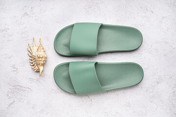 Turquoise flip-flops with shell on white grunge background