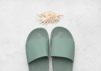 Turquoise flip-flops with shell on white grunge background