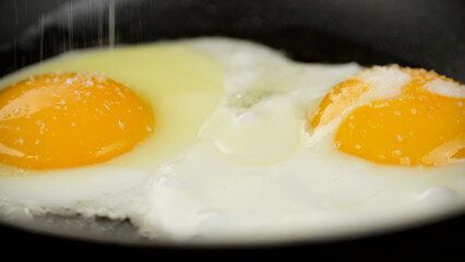 Cooking eggs in frying pan, close up