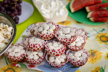 A picnic table full of delicious food. Homemade cupcakes.
