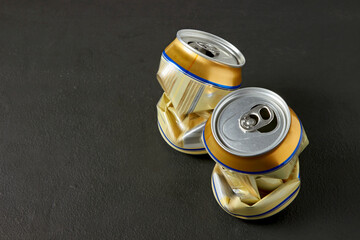 Flattened aluminum cans of beer on a black kitchen table
