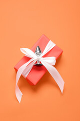 Gift box with anal plug on orange background