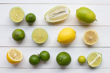 Ripe lemons and limes on white wooden.