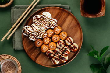 set of Asian sushi rolls with cheese caps on a wooden plate