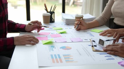 Group of young Asian business people brainstorming, looking at laptop computer.
