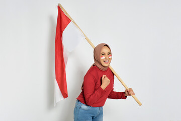 Excited young Asian women celebrate Indonesian independence day on 17 August by holding the...