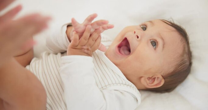 Infant baby, clapping hands and bed with parent, care or learning with smile, love or childhood development. Young happy kid, nursery or bedroom with teaching, applause or excited face in family home