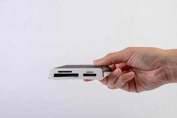 Close Up of external generic USB 3.0 Card Reader in hand isolated on white background.