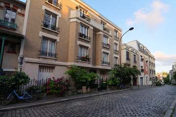 Fototapeta na wymiar Cobbled street on the Butte Bergeyre in 19th arrondissement of Paris city