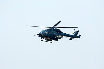 Combat Helicopter is going to attack enemy. Helicopter is flying on isolated blue sky.