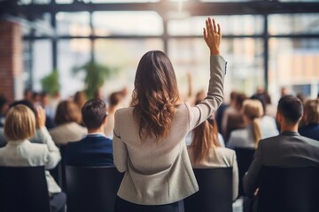 Rear view of a casual businesswoman raising one arm in a conference meeting