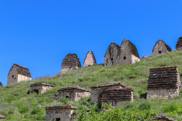 city of the dead Dargavs necropolis with landscape of the mountains with sky and clouds on the background