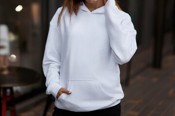 Woman Showcasing a white Hoodie for Logo Branding. Streetwear clothing mock-up. Logo on shirt...