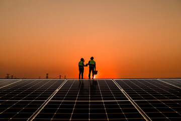 Engineers walking on roof inspect check and Maintenace solar cell panel by hold blue print ,solar...