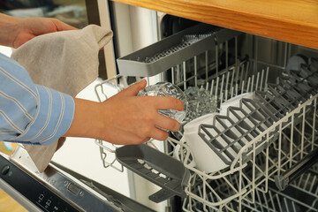 Open dishwasher with metal shelves for dishes