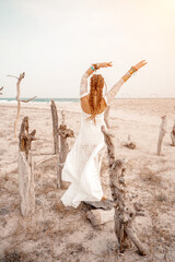 woman sea white dress. Model in boho style in a white long dress and silver jewelry on the beach....