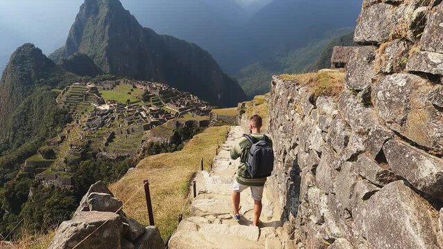 4k man walking down stairs lost city in Cusco, Machu pichu city in Peru.
