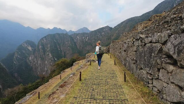 4k woman running and walking on lost city in Cusco, Machu Pichu city in Peru.