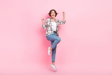 Full body photo of astonished business lady raise fists up jumping crazy celebrate black friday discounts isolated on pink color background