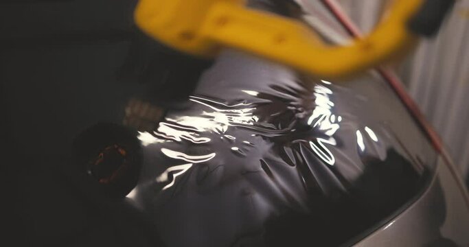 Car tinting windows - Worker specialist applying tint foil on car window 4k video