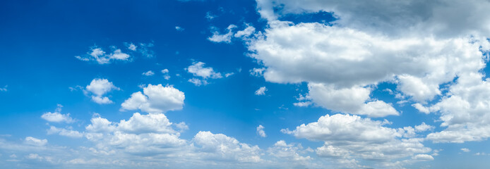 Panorama of a blue sky with beautiful, white fluffy clouds as a background or texture