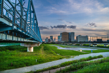 Fototapeta premium 夕暮れ時の多摩川緑地公園と川崎の街並み【東京都・大田区－神奈川県・川崎市】