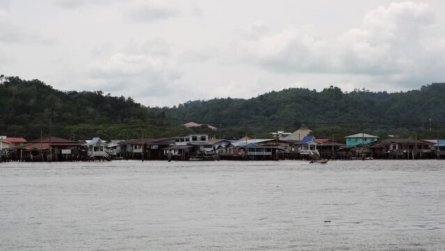4K footage of Kampong Ayer in Brunei with rural houses and green mountains with cloudy sky