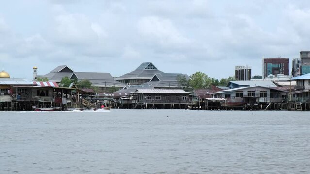 4K view of Kampong Ayer in Brunei with rural houses and green mountains with cloudy sky