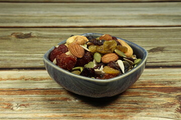 Bowl of dried fruit. Pile of mixed nut and raisin serving in the small plate. Famous nutrition baked snack in Asia restaurant. Various topping in bakery shop.