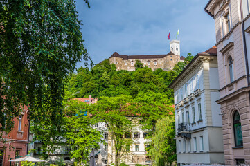 Fototapeta na wymiar A view past ornate buildings towards the Castle in Ljubljana, Slovenia in summertime