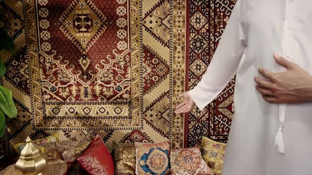 Man wearing traditional white kandura from the emirates spending time in his arab house. Concept about middle eastern cultures and lifestyles