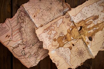 Closeup shot of antique maps on a wooden table.
