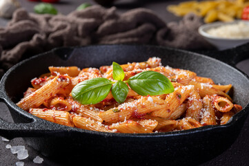 Penne Pasta with tomato sauce, parmesan and fresh basil in a pan.