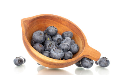 A few sweet blueberries with a wooden cup, macro, isolated on a white background.